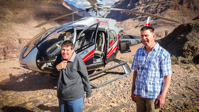 two men in front of a helicopter at the grand canyon
